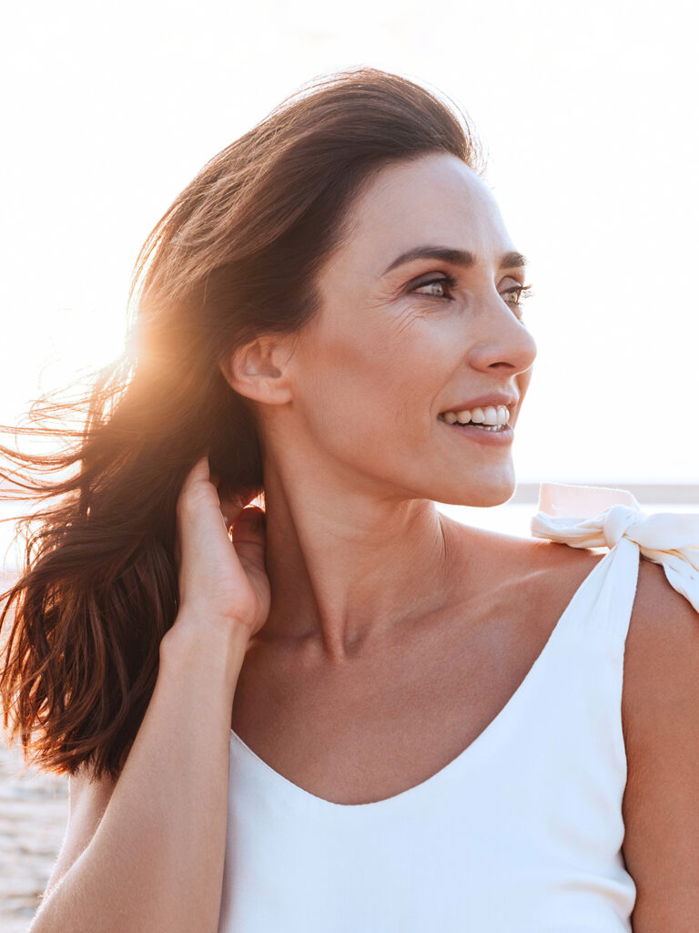 Woman in white top staring off to the right.